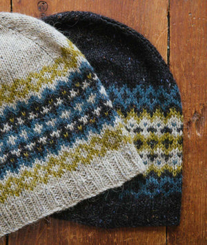 Churchmouse Colorwork Cap knit in Rowan Felted Tweed.  Depicted  are two hats knit in the Sea colourway: One with light background the other with dark background.